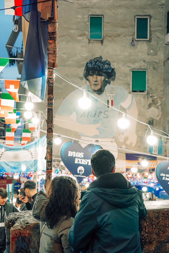 Vibrant street with Maradona mural in Naples, showcasing urban culture and art.
